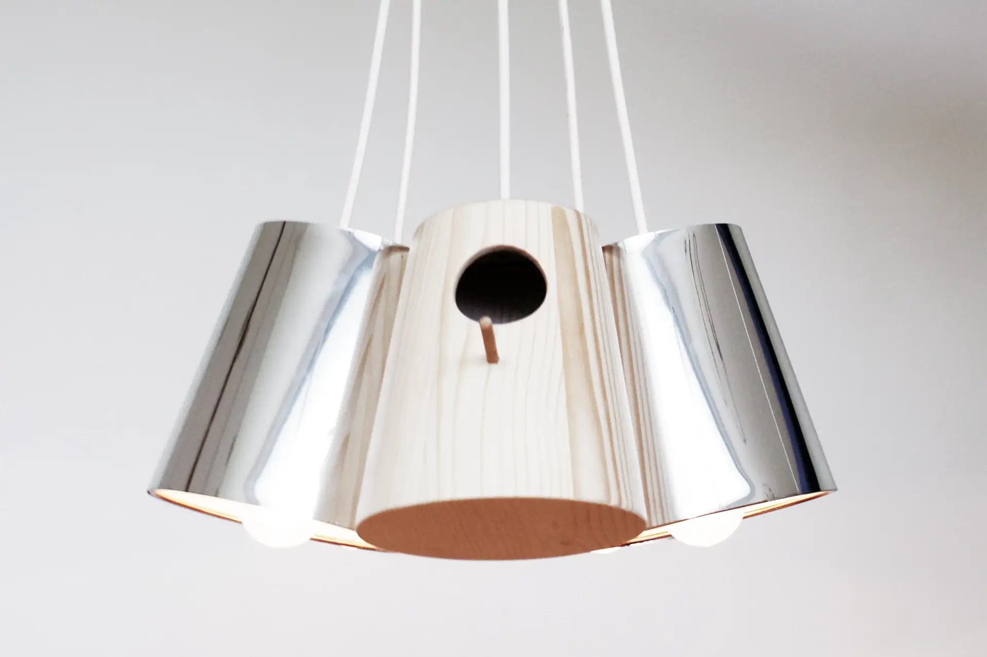 Závesná dizajnová lampa Birdlamp so striebornými tienidlami v tvare vtáčích príbytkov a figúrkou vtáčika